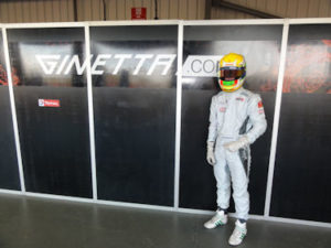 ben in his kit and helmet next to a ginetta sign